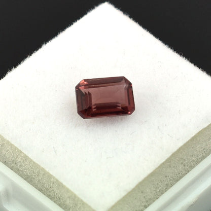 Rectangular-cut red gemstone with a deep burgundy color.