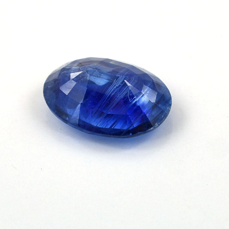 Oval-shaped blue gemstone with facets and a deep sapphire color.