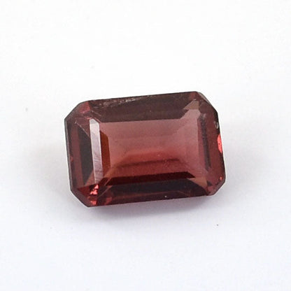 Rectangular-cut red gemstone with a deep burgundy hue.