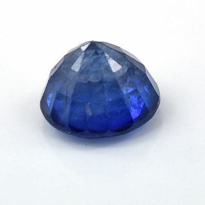 Deep blue faceted sapphire gemstone with a rounded triangular shape.