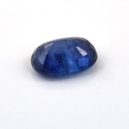 Deep blue oval-cut gemstone, likely a sapphire.