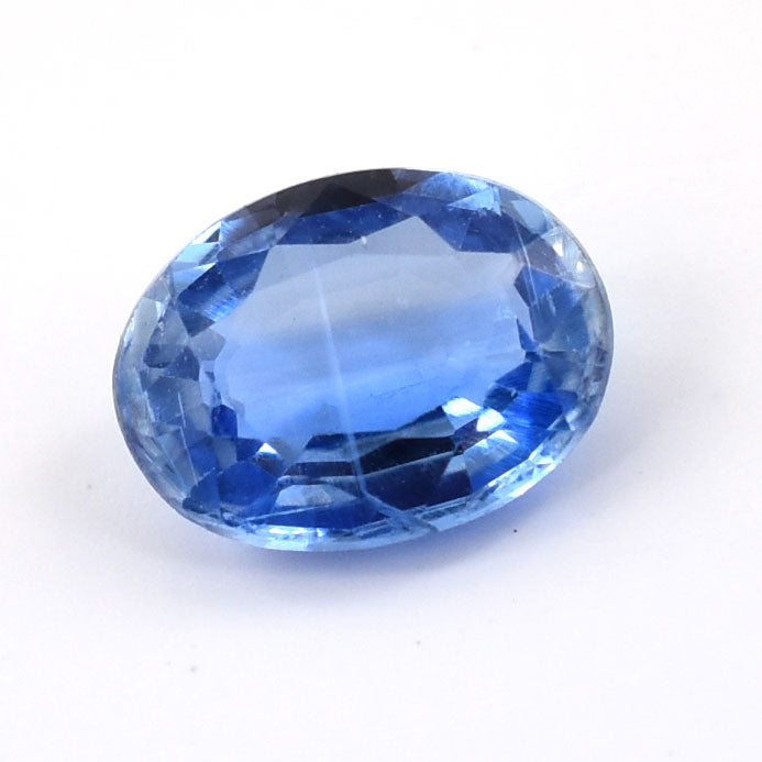 Oval-cut blue gemstone with facets reflecting light.