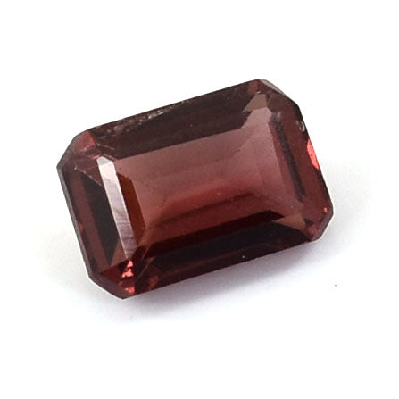 Rectangular-cut deep red gemstone with facets reflecting light.