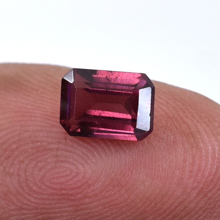 Emerald-cut deep pink gemstone, likely a tourmaline or rhodolite garnet.