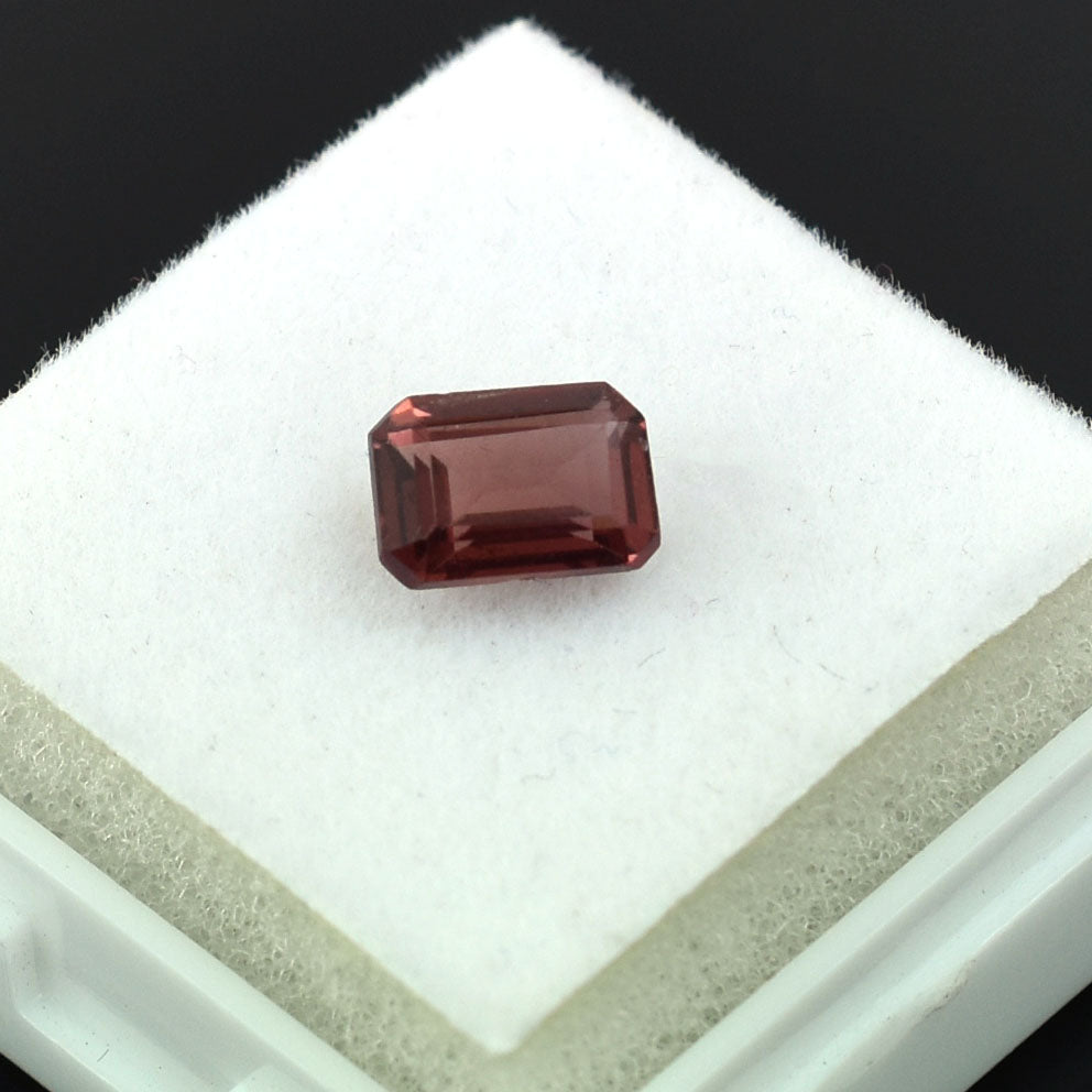 Rectangular-cut red gemstone, likely a garnet or ruby.