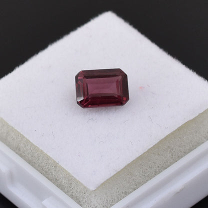 Rectangular-cut deep red gemstone, likely a ruby or garnet.