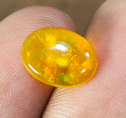 Vibrant yellow-orange opal gemstone with internal flashes of color.