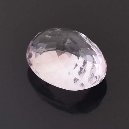 Oval-shaped, faceted gemstone or crystal with a pale, translucent appearance.