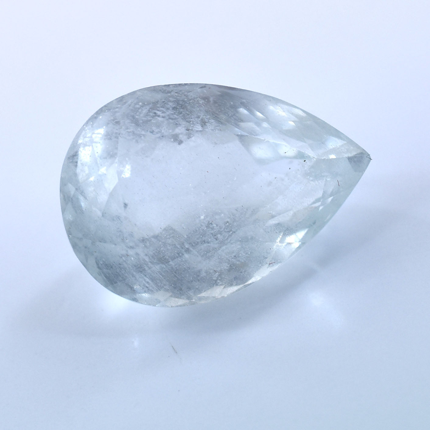 Pear-shaped, translucent gemstone or crystal with a cloudy appearance.