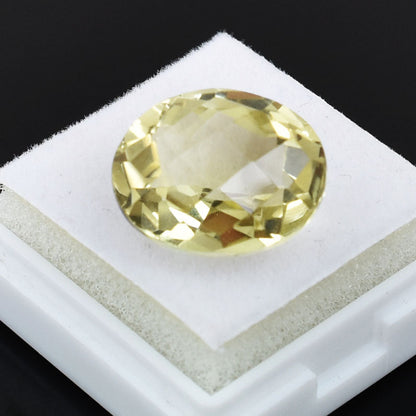 Oval-cut pale yellow gemstone, likely a citrine or yellow sapphire.