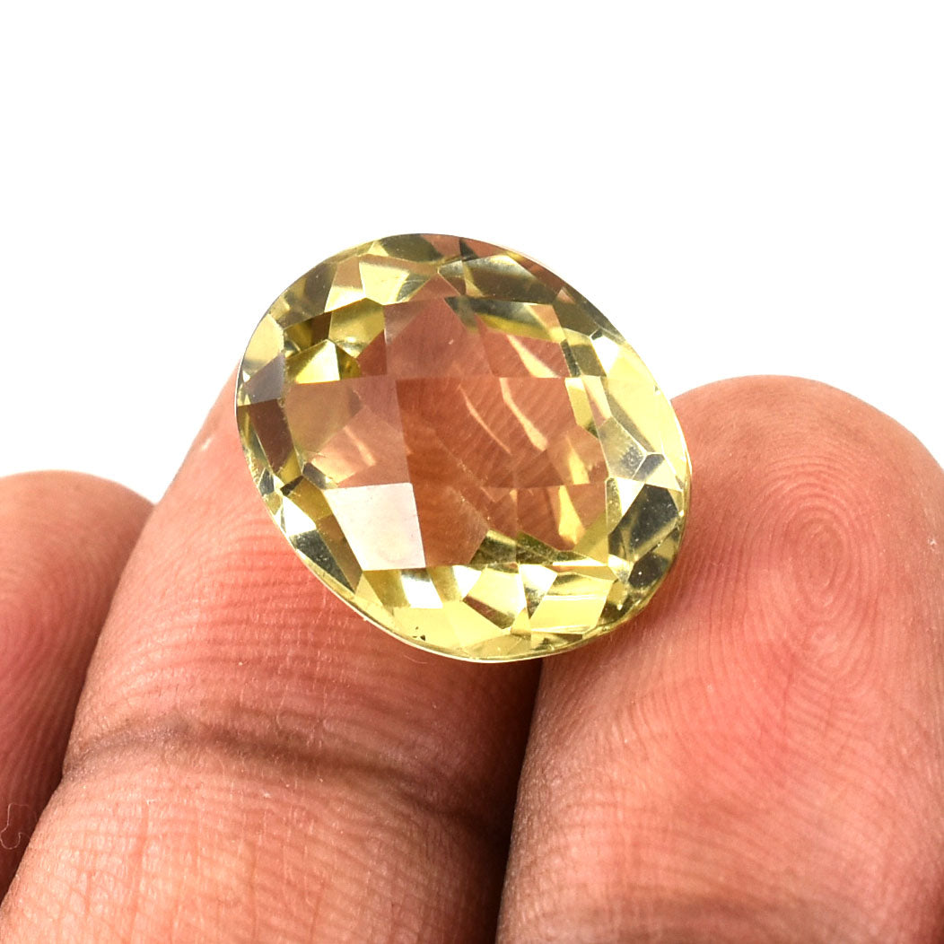 Faceted yellow gemstone held between fingers.