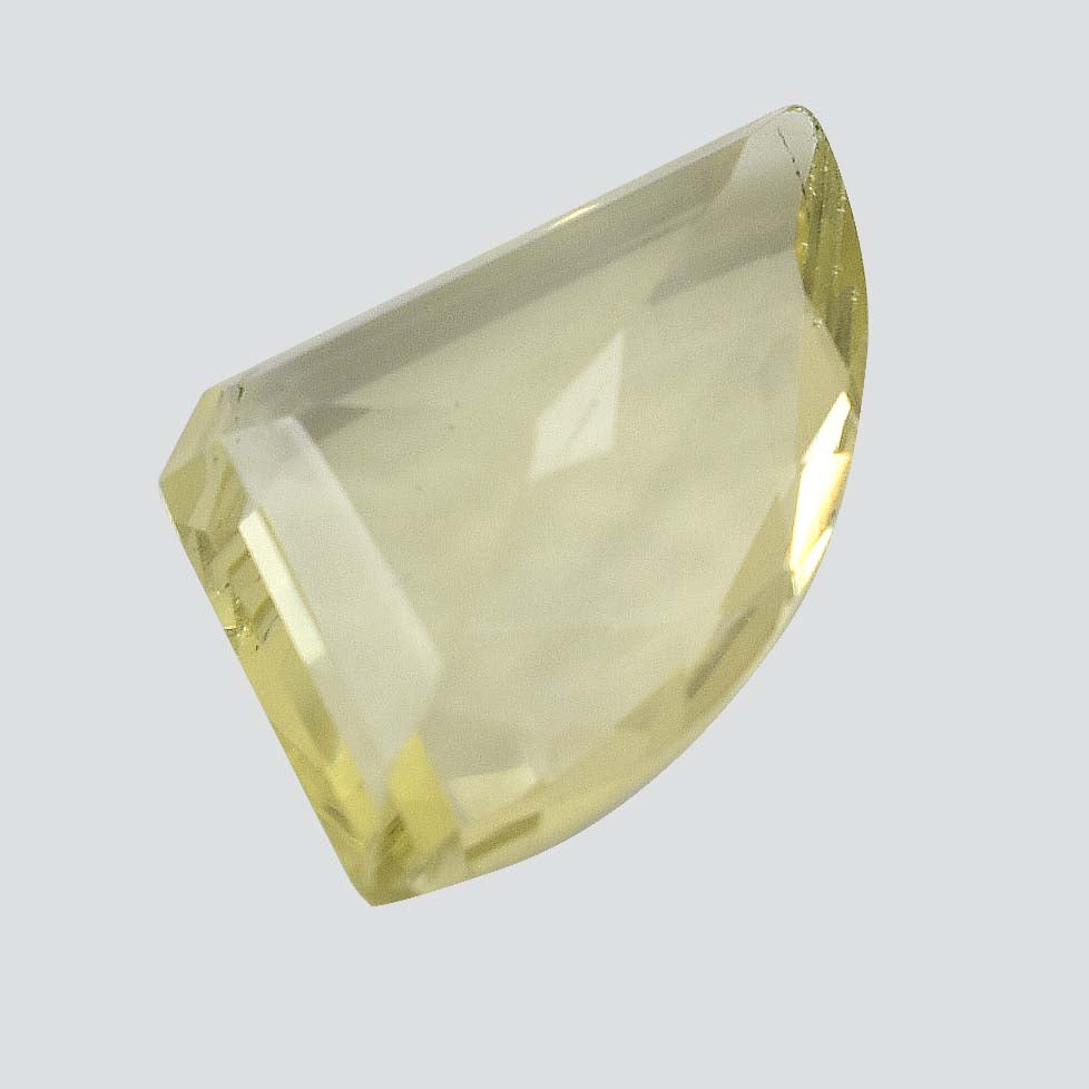 Pale yellow gemstone with a faceted, asymmetrical shape.