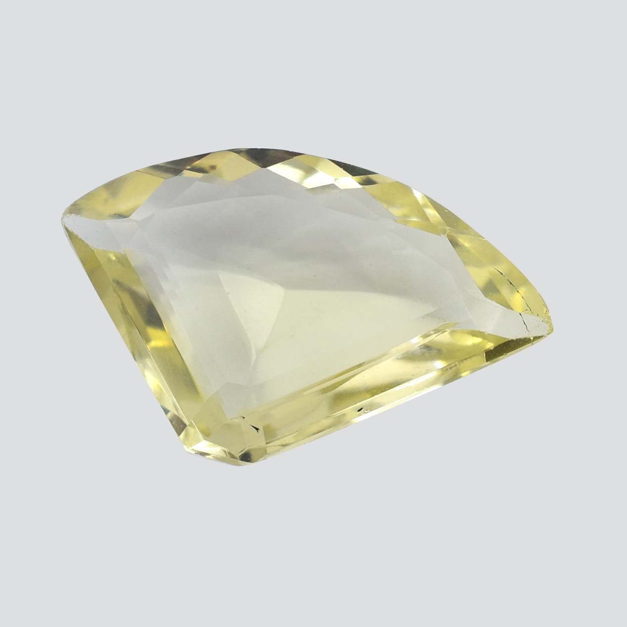 Pale yellow gemstone with a faceted, asymmetrical cut.