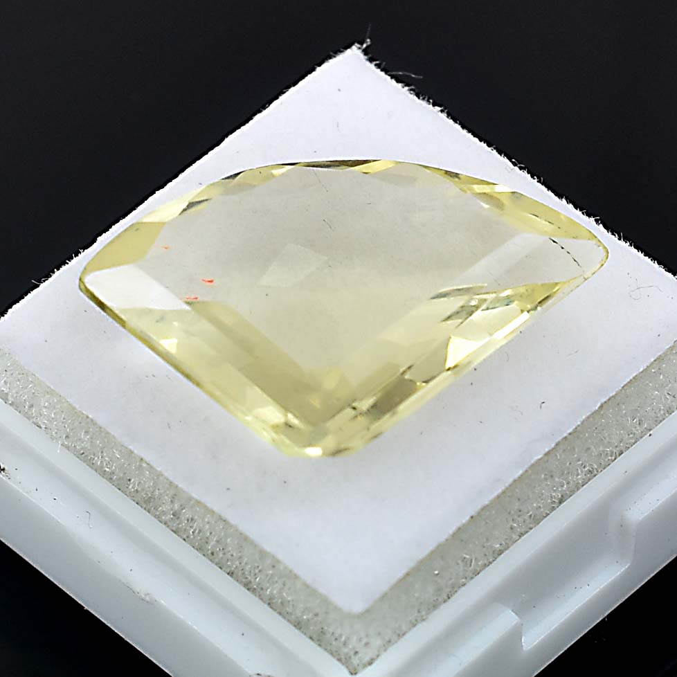 Pale yellow gemstone with a faceted, triangular cut shape.