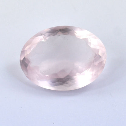 Oval-cut rose quartz gemstone with faceted surfaces.