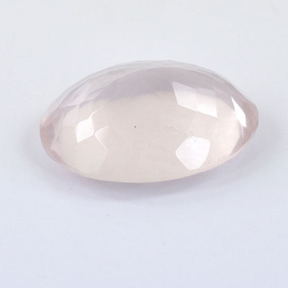 Oval-cut rose quartz gemstone with faceted surfaces.