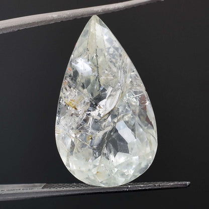 Teardrop-shaped clear gemstone with internal inclusions and facets.