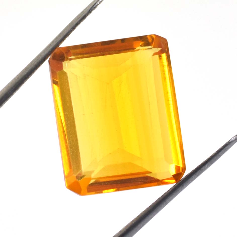 Rectangular-cut yellow gemstone held between two metal prongs.