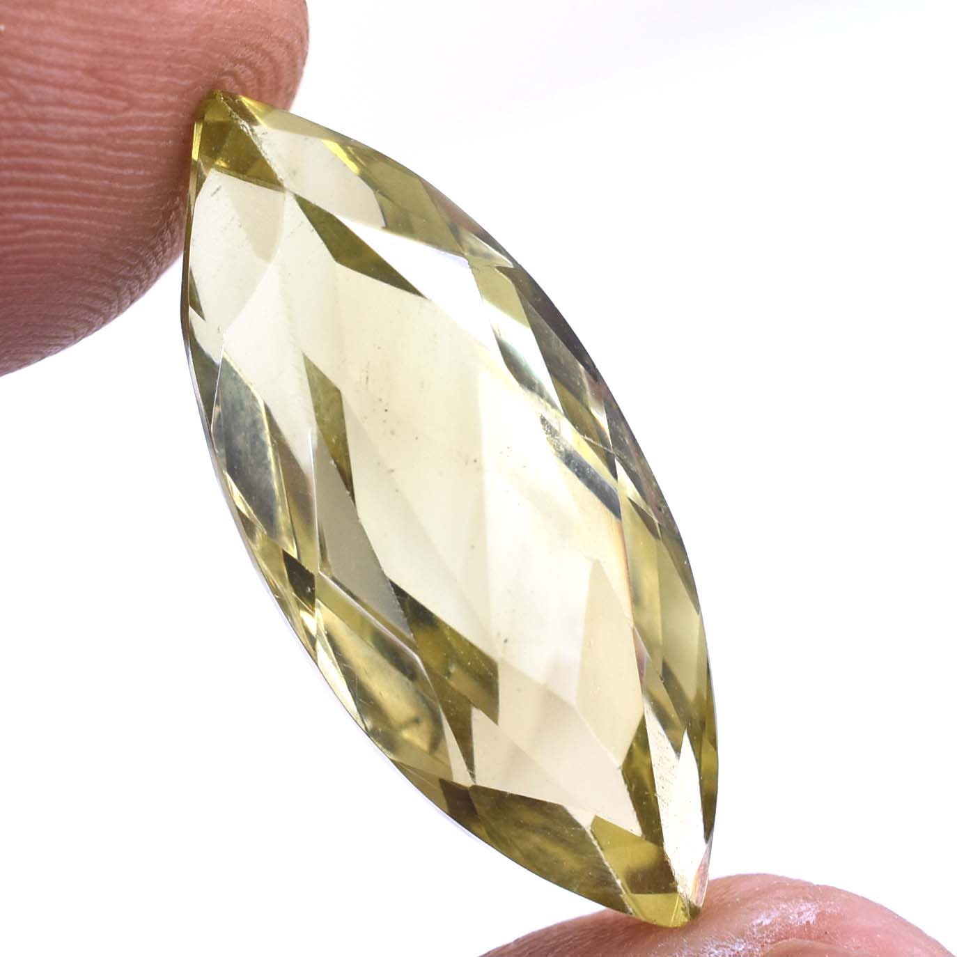 Faceted, pale yellow gemstone held between two fingers.