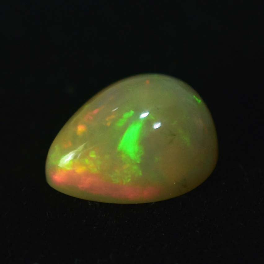 Teardrop-shaped opal gemstone with green and orange flashes of color.