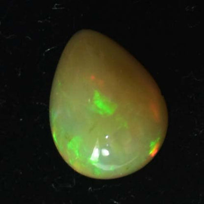 Opal gemstone with vibrant green and orange flashes of color.