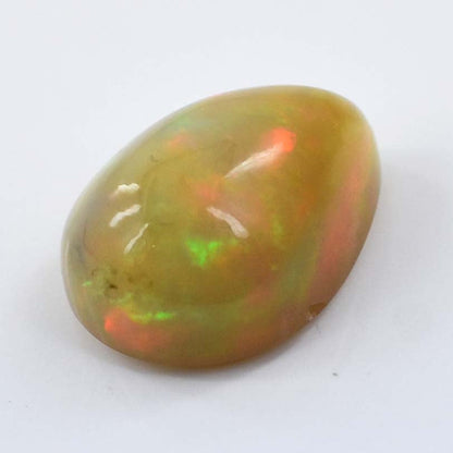 Oval-shaped opal gemstone with green and orange flashes of color.