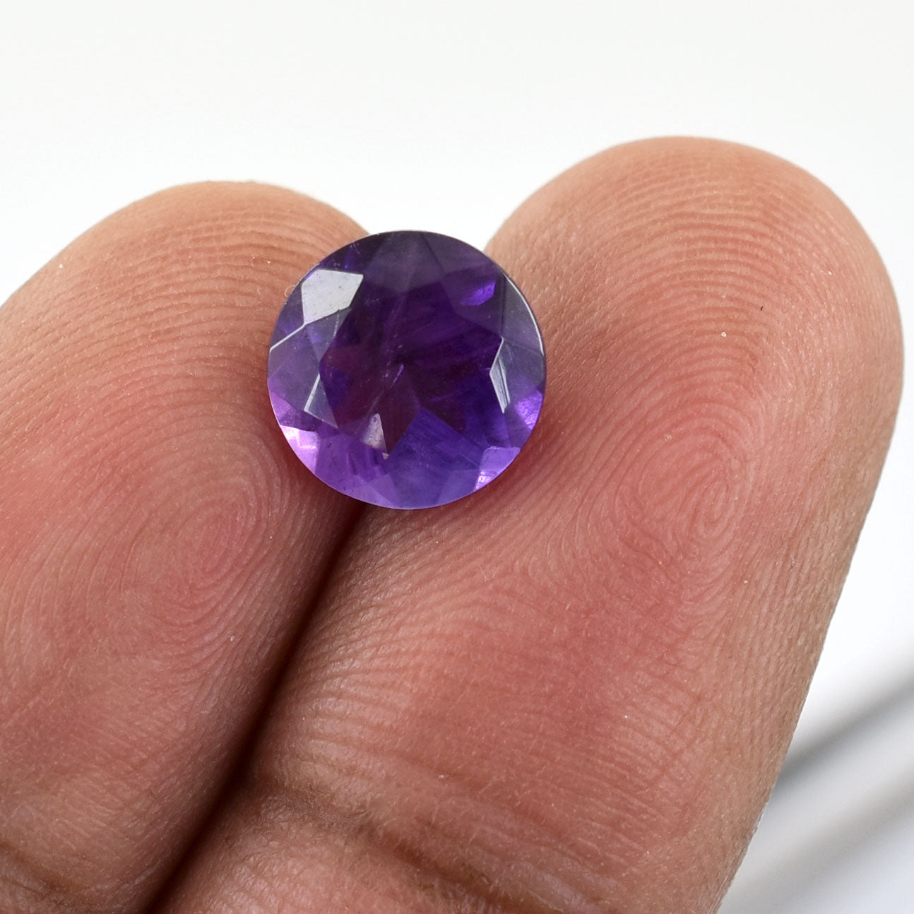 Round-cut purple gemstone, likely an amethyst.