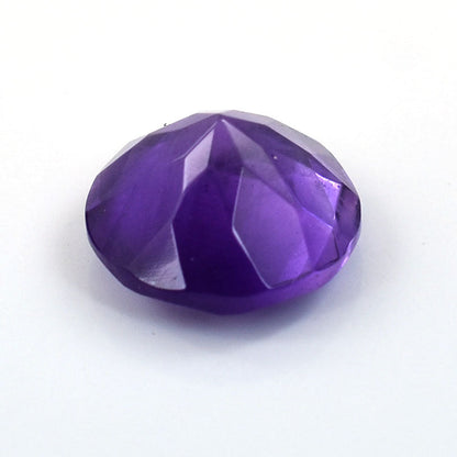 Faceted purple gemstone or crystal with a rounded oval shape.