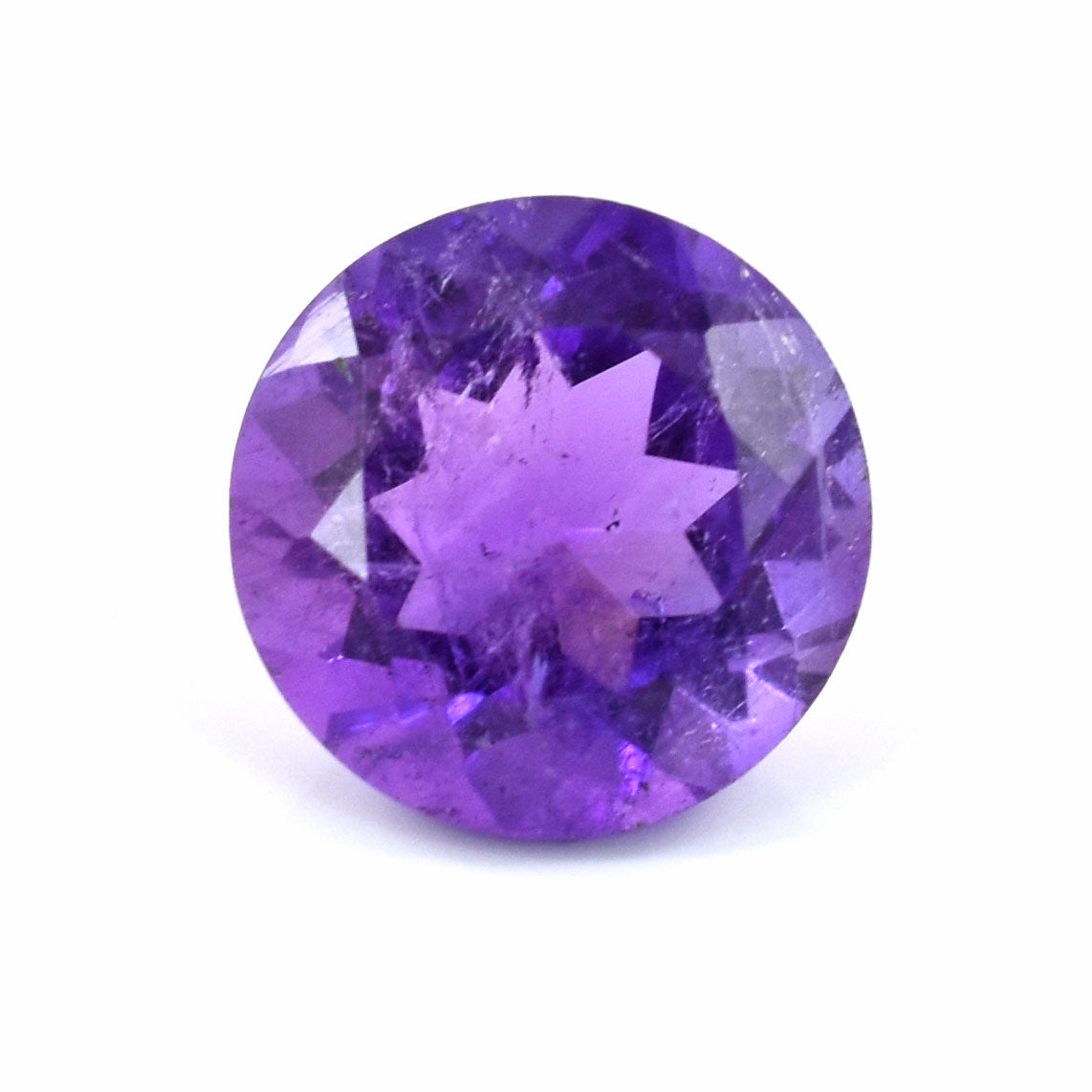 Round-cut purple gemstone with facets reflecting light.