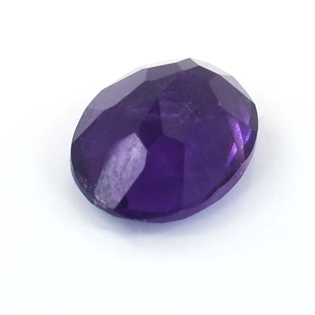 Oval-cut purple gemstone with faceted surfaces.