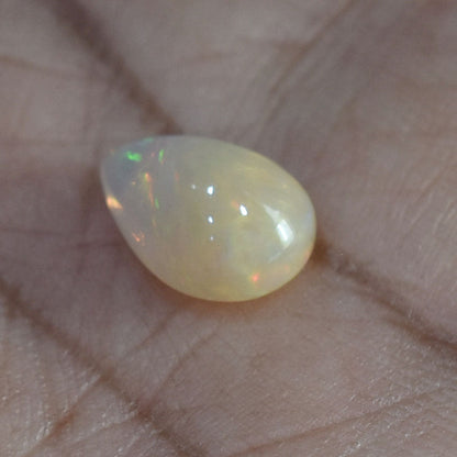 Teardrop-shaped opal gemstone with iridescent flashes of color.