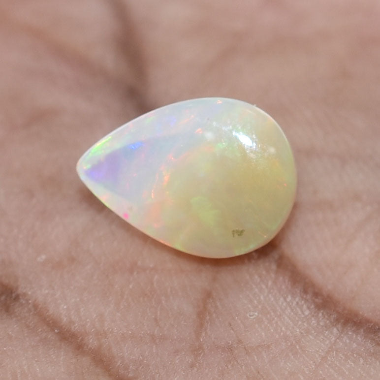 Teardrop-shaped opal gemstone with iridescent colors.