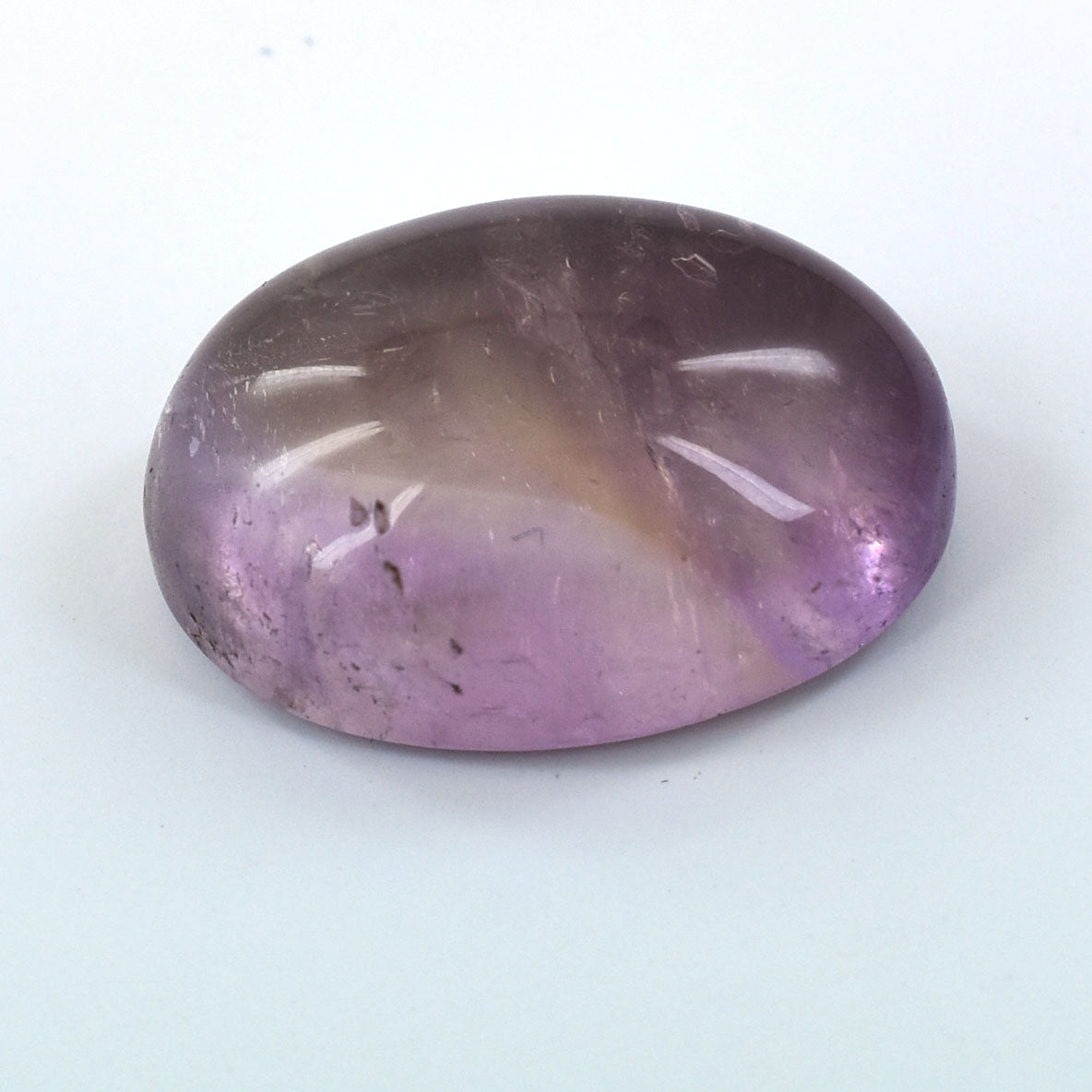 Oval-shaped purple amethyst gemstone with some cloudy inclusions.