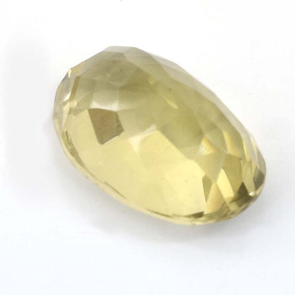 Faceted pale yellow gemstone with an oval shape.