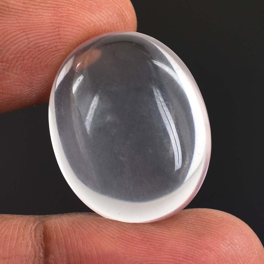 Smooth, oval-shaped, translucent gemstone held between fingers.