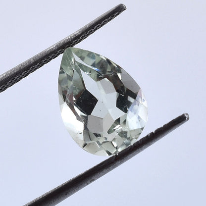 Pear-shaped, faceted gemstone with a pale green color.