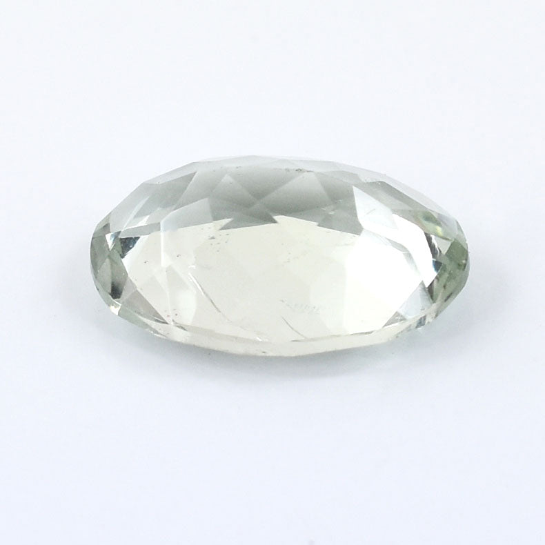 Oval-cut, transparent gemstone with a pale green hue.