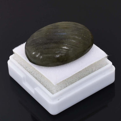 Smooth, oval-shaped green stone resting on a white pedestal.