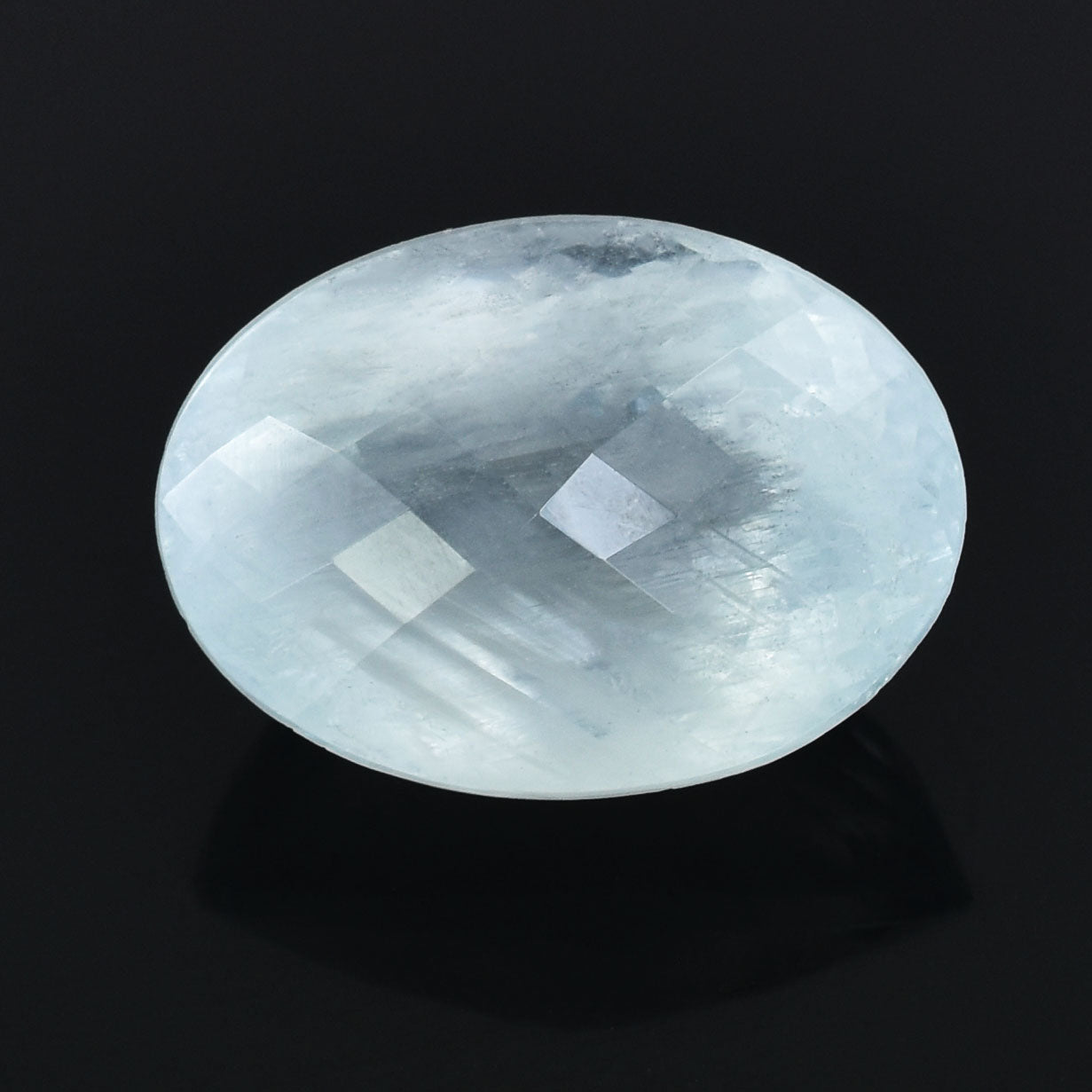 Oval-shaped, faceted gemstone with a pale, translucent appearance.