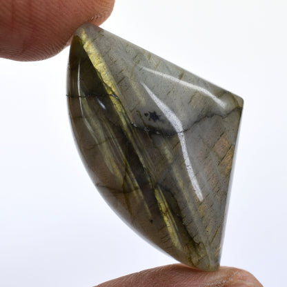 Polished gemstone or crystal with a triangular shape and greenish-gray coloration.