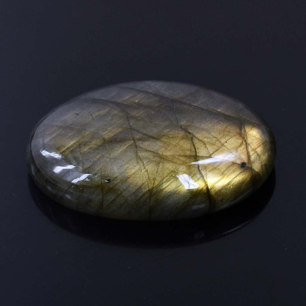 Polished labradorite gemstone with golden flashes and dark inclusions.