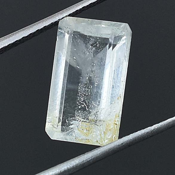 Rectangular, transparent crystal or gemstone with visible internal inclusions.