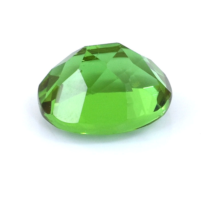 Faceted green gemstone or crystal with a round, flat-bottomed shape.