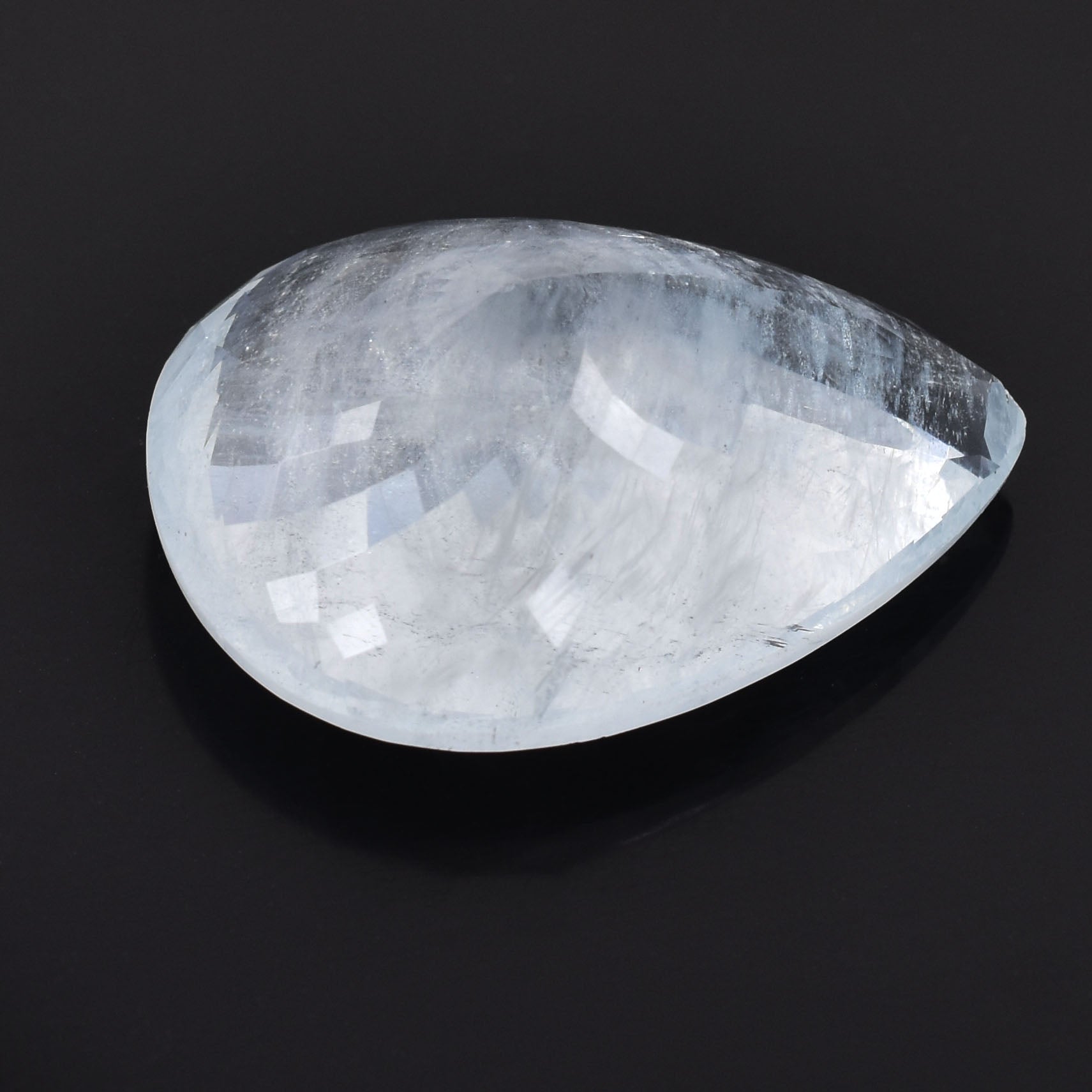 Teardrop-shaped, translucent crystal or gemstone with a smooth, polished surface.