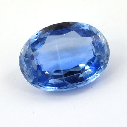 Oval-cut blue gemstone with facets reflecting light.