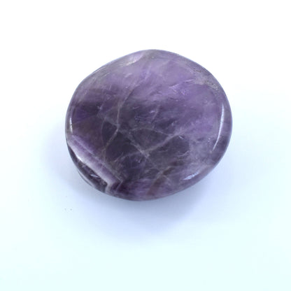 Smooth, polished purple gemstone with a rounded, disc-like shape.