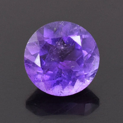 Faceted round purple gemstone, likely an amethyst.