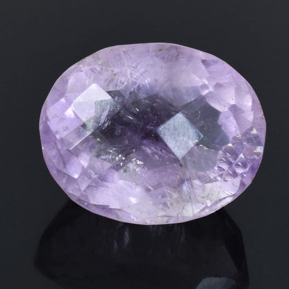 Oval-cut light purple gemstone with facets reflecting light.