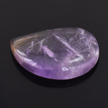 Polished purple amethyst gemstone with a smooth, rounded shape.