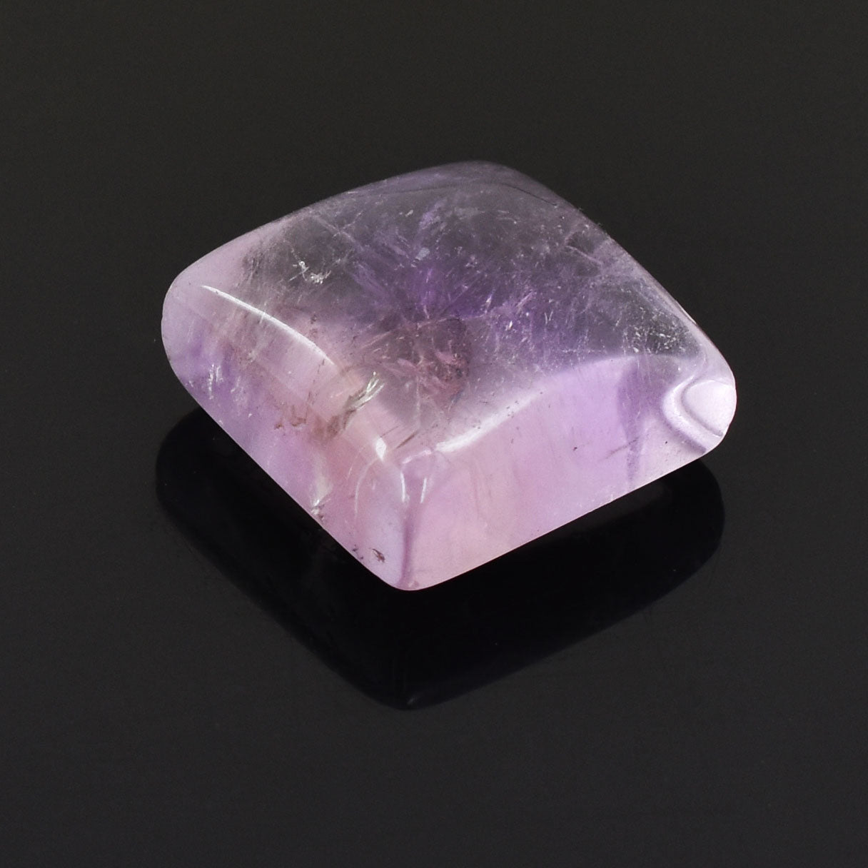 Polished amethyst gemstone with a rounded square shape and soft purple hue.